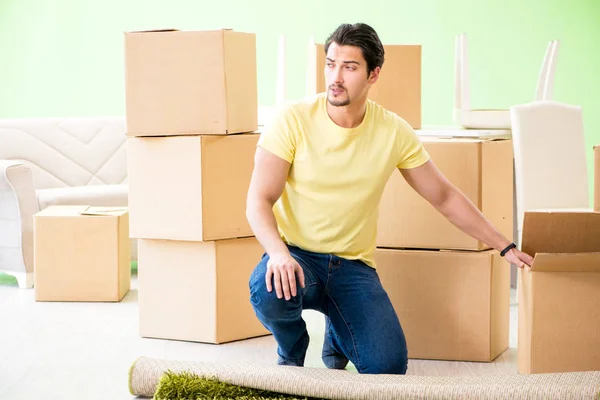 Joven hombre guapo mudándose a casa nueva con cajas —  Fotos de Stock