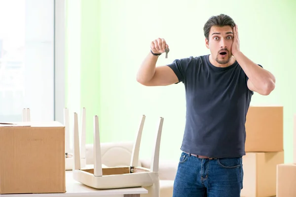 Joven hombre guapo mudándose a casa nueva con cajas — Foto de Stock