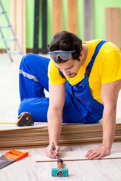 Professional contractor laying flooring at home