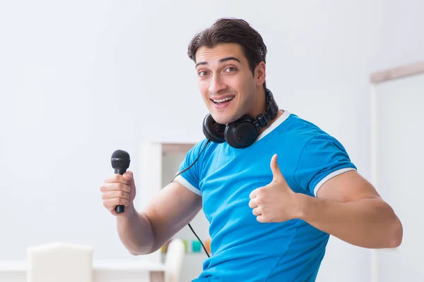 Joven hombre guapo cantando karaoke en casa —  Fotos de Stock