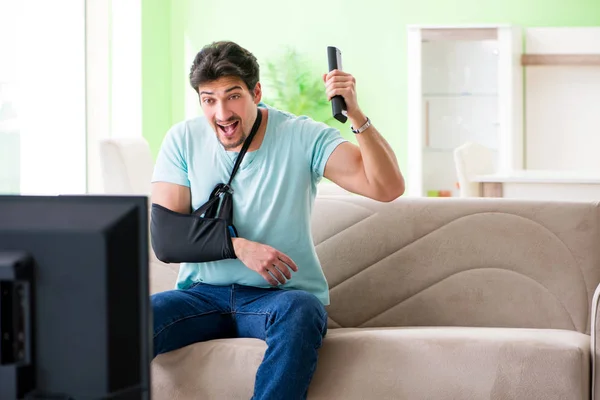 Braccio uomo ferito seduto sul divano a guardare la tv — Foto Stock