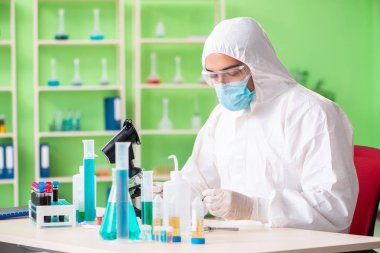 Laboratuvarda yeni bir deney üzerinde çalışan kimyager.