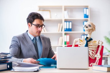 İskeletle çalışan bir iş adamı.