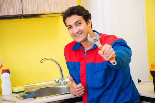 Сантехник ремонтирует кран на кухне — стоковое фото