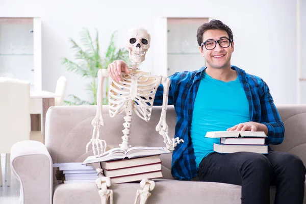 Студент, обучающийся со скелетом, готовится к экзаменам — стоковое фото