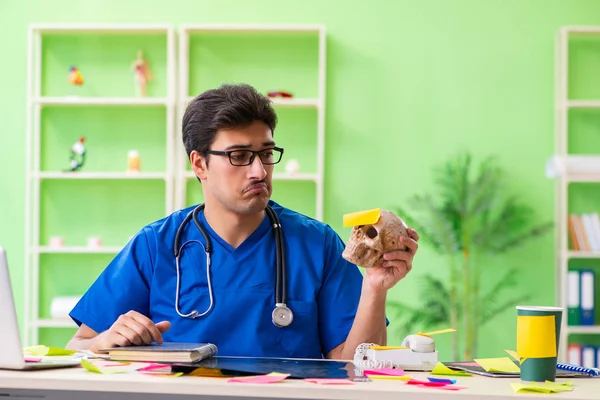 Hastanede oturan genç doktor, birçok çelişkili önceliğe sahip. — Stok fotoğraf