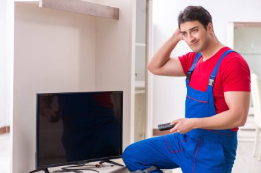 Profesyonel tamir mühendisi bozuk televizyonu tamir ediyor.
