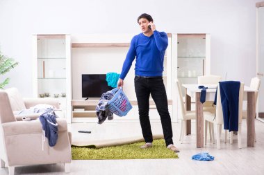 Genç adam çamaşırhane için kirli çamaşır topluyor.