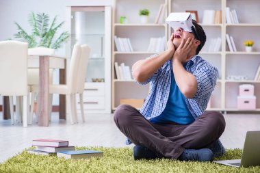 Evde sanal gerçeklik gözlükleriyle serbest çalışan bir öğrenci.