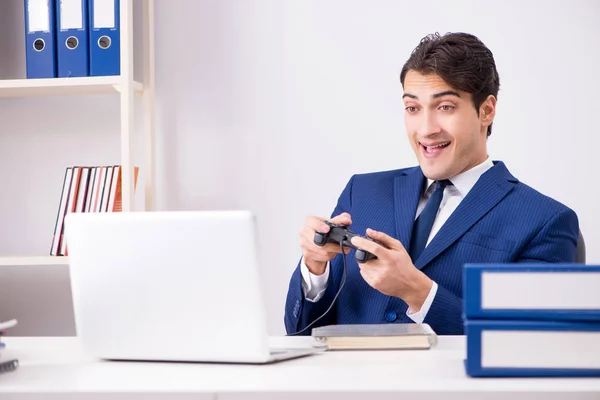 Junger gutaussehender Geschäftsmann spielt Computerspiele im Büro — Stockfoto