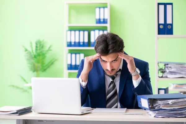 Empresario descontento con el trabajo excesivo sentado en la oficina — Foto de Stock