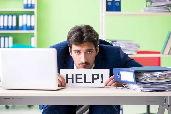 Businessman unhappy with excessive work sitting in the office — Stock Photo, Image