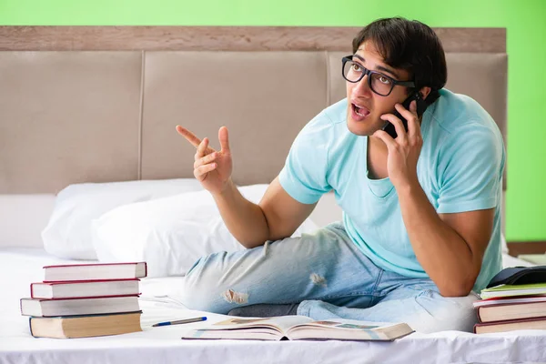 Studenten bereiden zich voor op examens thuis in de slaapkamer zitten op de be — Stockfoto