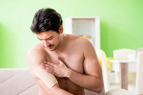 Hombre aplicando pimienta Capsicum yeso para aliviar el dolor — Foto de Stock