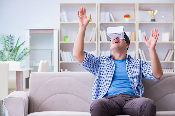 Evde sanal gerçeklik gözlüklü bir adam oynuyor.