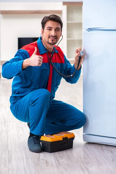 Professional contractor repairing broken fridge — Stock Photo, Image