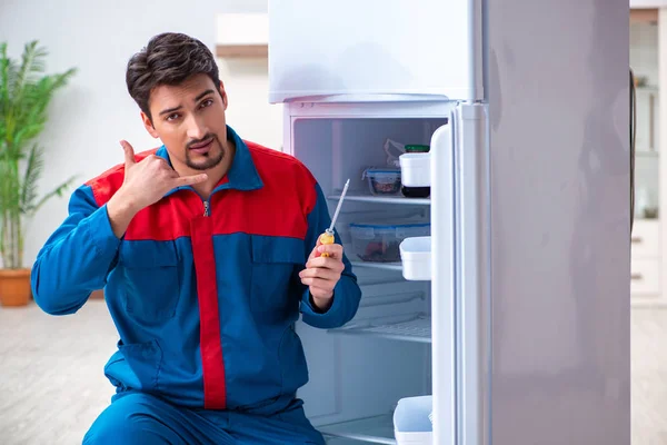 Professional contractor repairing broken fridge