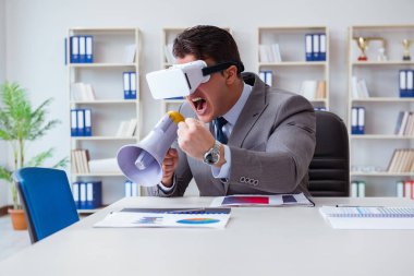 Ofiste sanal gerçeklik gözlüklü bir iş adamı var.