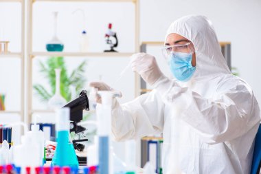 Laboratuvarda kimyasallar üzerinde çalışan genç bir kimyager.