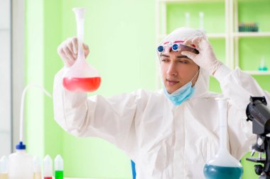 Laboratuvarda yeni bir deney üzerinde çalışan kimyager.
