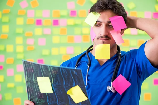 Young doctor with many reminders and urgent work — Stock Photo, Image