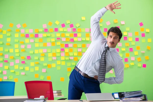 Mann im Büro mit vielen widersprüchlichen Prioritäten bei Übungen — Stockfoto