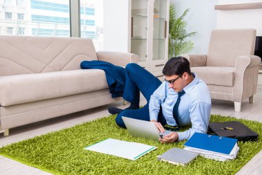 İş adamı eve iş getirip fazla mesai yapıyor.