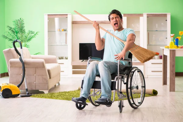Uomo disabile sulla sedia a rotelle casa di pulizia — Foto Stock