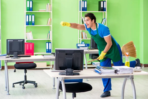 Jonge mannelijke knappe professionele schoonmaak vloer met bro — Stockfoto