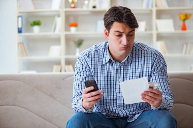 Kanepede ilaç ve reçeteyle oturan genç adam.