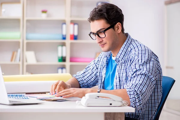 Joven diseñador trabajando en un nuevo proyecto y eligiendo colores — Foto de Stock