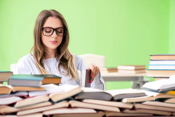 Giovane studentessa che si prepara per gli esami con molti libri — Foto Stock