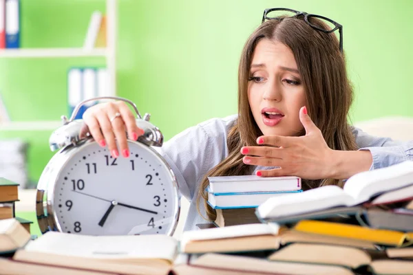 Jonge vrouwelijke student bereidt zich voor op examens met veel boeken in de tijd — Stockfoto