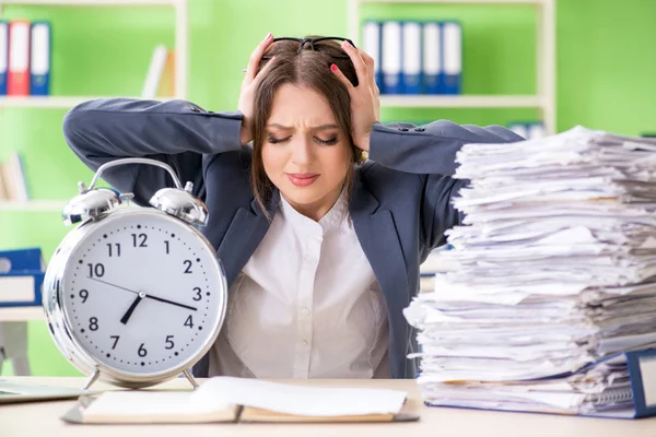 Jonge vrouwelijke werknemer zeer druk met lopende papierwerk in de tijd m — Stockfoto