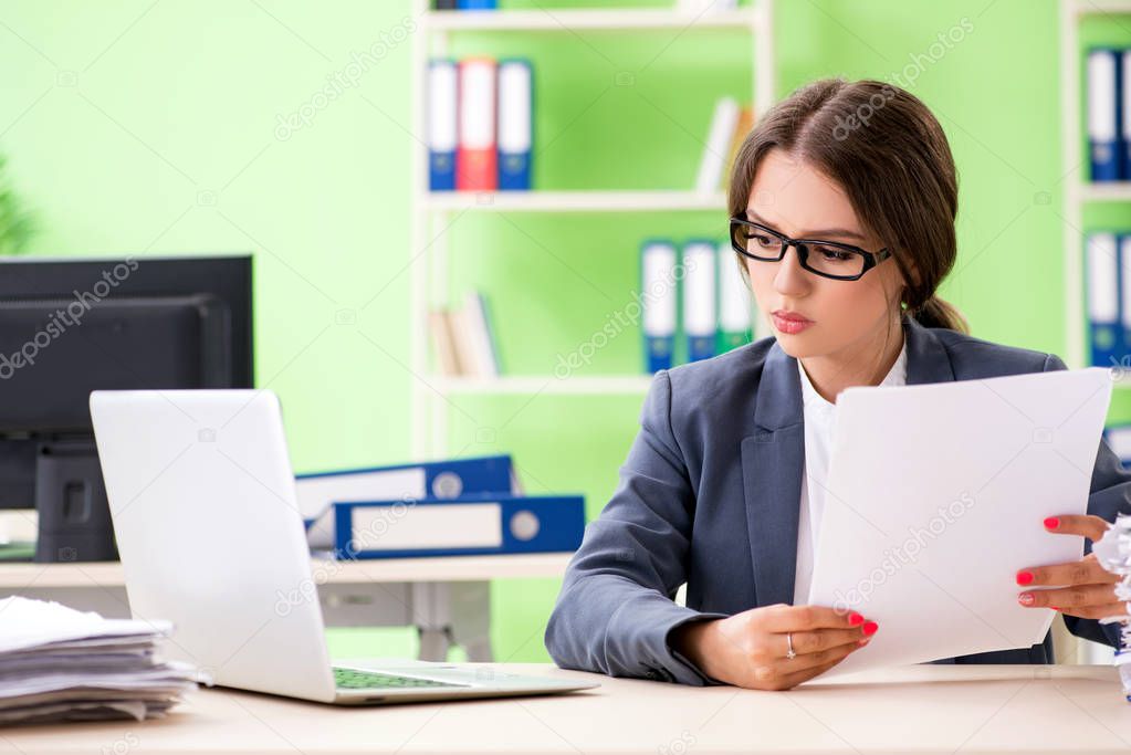 Young female employee very busy with ongoing paperwork