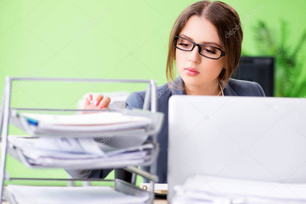 Young female employee very busy with ongoing paperwork