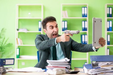 İşadamı ofiste otururken aşırı çalışmaktan kızgın.