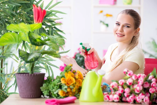 Jovem mulher regando plantas em seu jardim — Fotografia de Stock