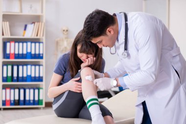 Spor sakatlığı geçiren hasta doktoru ziyaret ediyor.