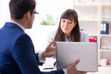 İş adamı doktorla sağlık sorunlarını tartışıyor