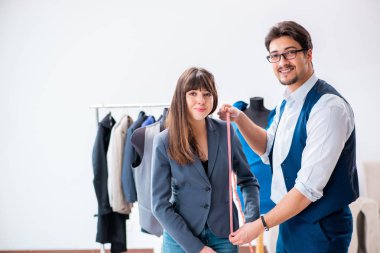 Profesyonel terzi resmi kıyafet için ölçü alıyor.