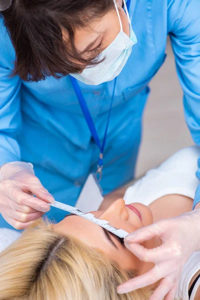 Vrouwelijke oogarts controleert vrouwelijke patiënt in oog doct — Stockfoto