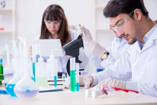 Tým chemiků pracujících v laboratoři — Stock fotografie