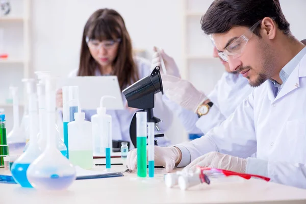 Equipe de químicos que trabalham no laboratório — Fotografia de Stock