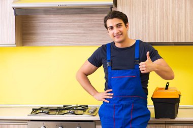 Genç müteahhit mutfak mobilyalarını monte ediyor.