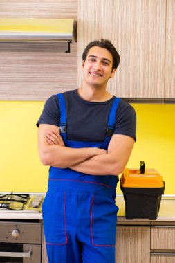 Genç müteahhit mutfak mobilyalarını monte ediyor.