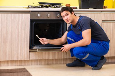 Genç müteahhit mutfak mobilyalarını monte ediyor.