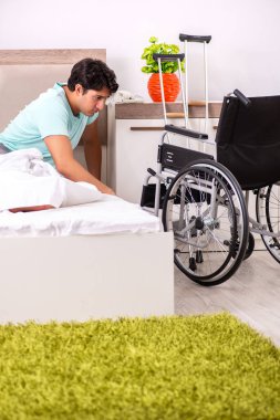 Genç yakışıklı engelli adam evde iyileşiyor. 