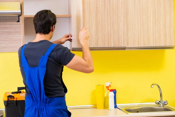 Jovem empreiteiro de serviços montagem de mobiliário de cozinha — Fotografia de Stock