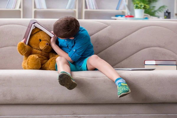 Kleine jongen die thuis boeken leest — Stockfoto